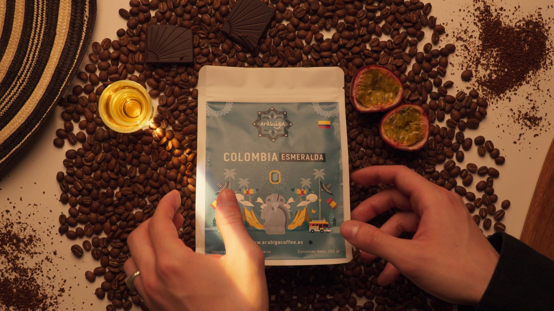 Manos con bolsas de café de Arábiga y granos sobre la mesa